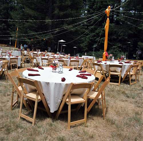 Dining tables set up in the field. -- 